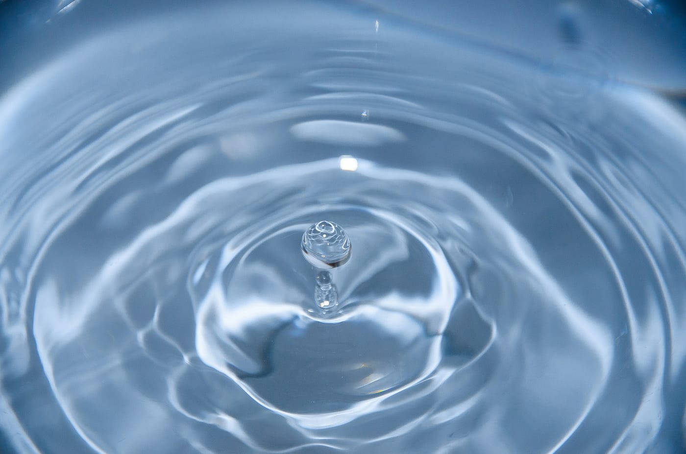 Close-up of a water droplet rippling on a clear surface