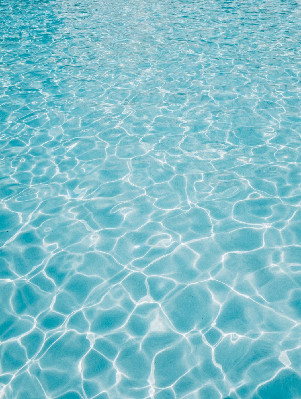 Close-up of clear, rippling turquoise pool water