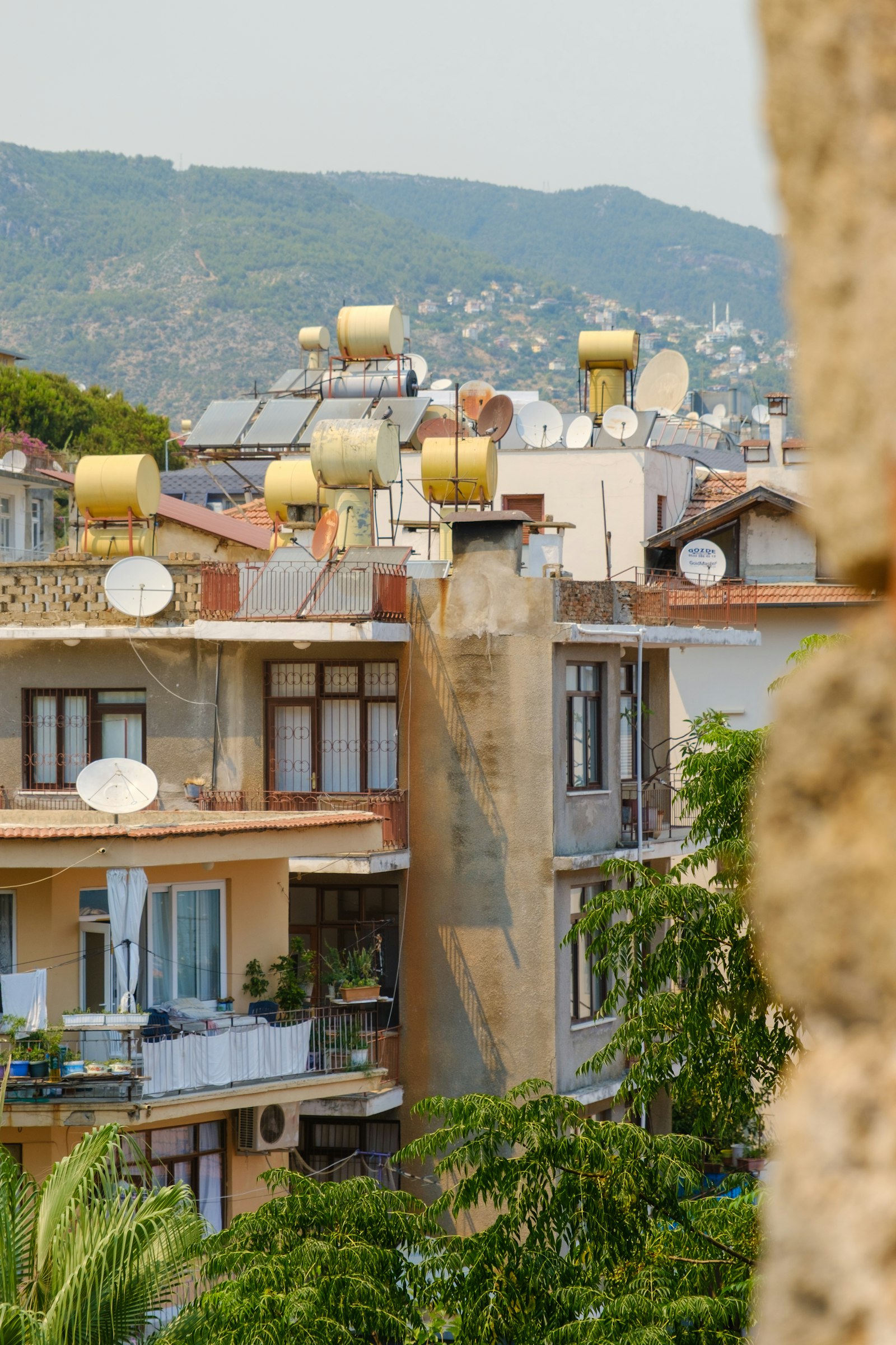 Solar water heater tanks on Mediterranean rooftops overlooking a mountain village